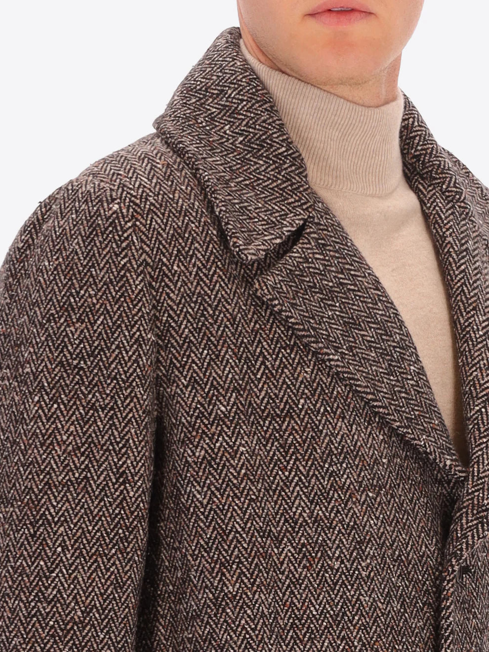 Male model wearing tobacco coloured overcoat by distretto12 with micro pattern with close up view