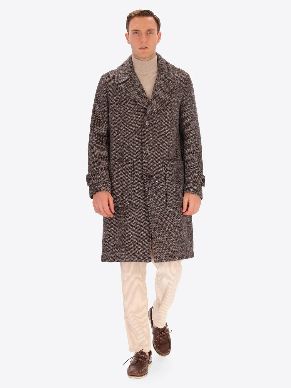 Male model wearing tobacco coloured overcoat by distretto12 with micro pattern with corduroy trousers