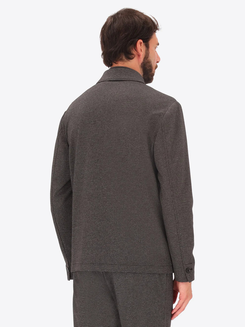 Male model wearing micro patterned shirt jacket by distretto12 in grey with back view
