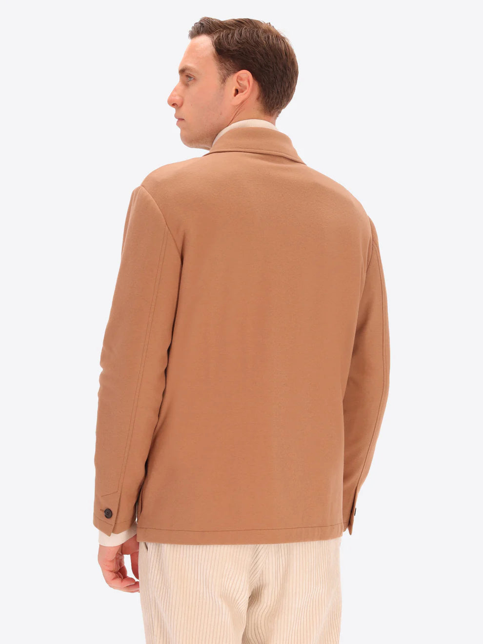 Male model wearing soft shirt jacket by distretto12 in camel colour with back turned
