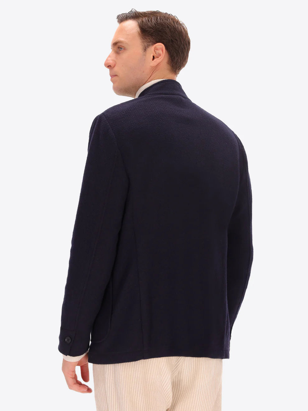 Navy knitted Distretto12 coreana jacket on a male model with his back turned
