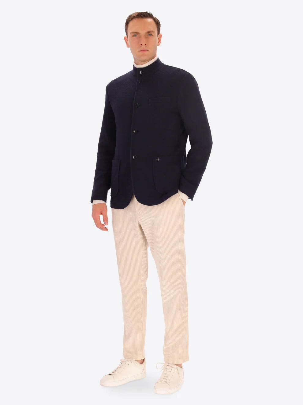Navy knitted Distretto12 coreana jacket on a male model paired with corduroy cream trousers