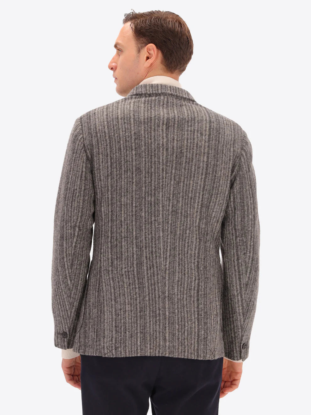 Male model wearing wool blend double breasted jacket in grey by distretto12 with back turned