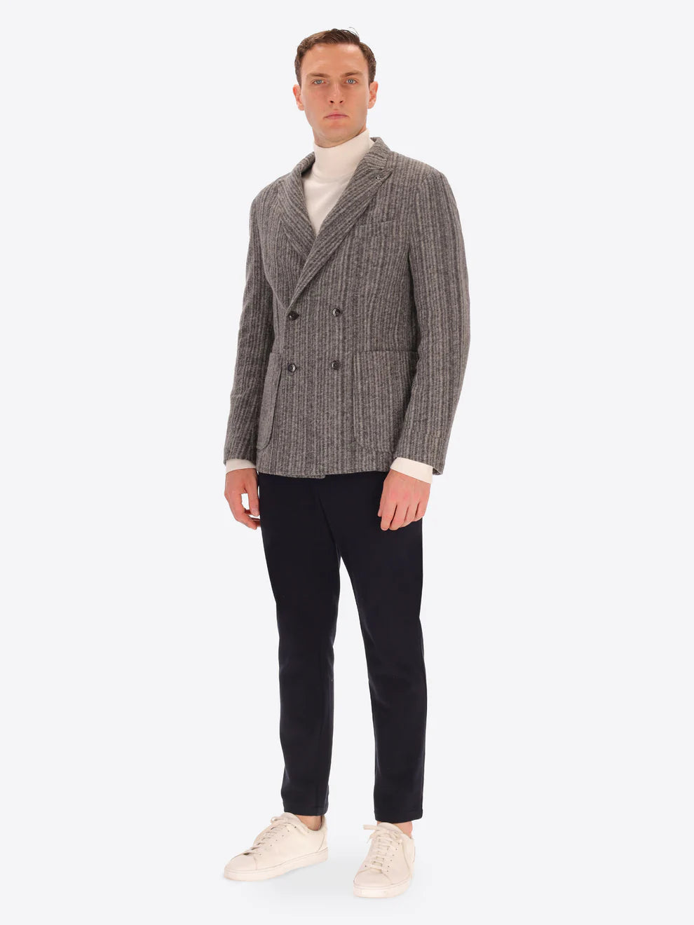 Male model wearing wool blend double breasted jacket in grey by distretto12 with navy trousers
