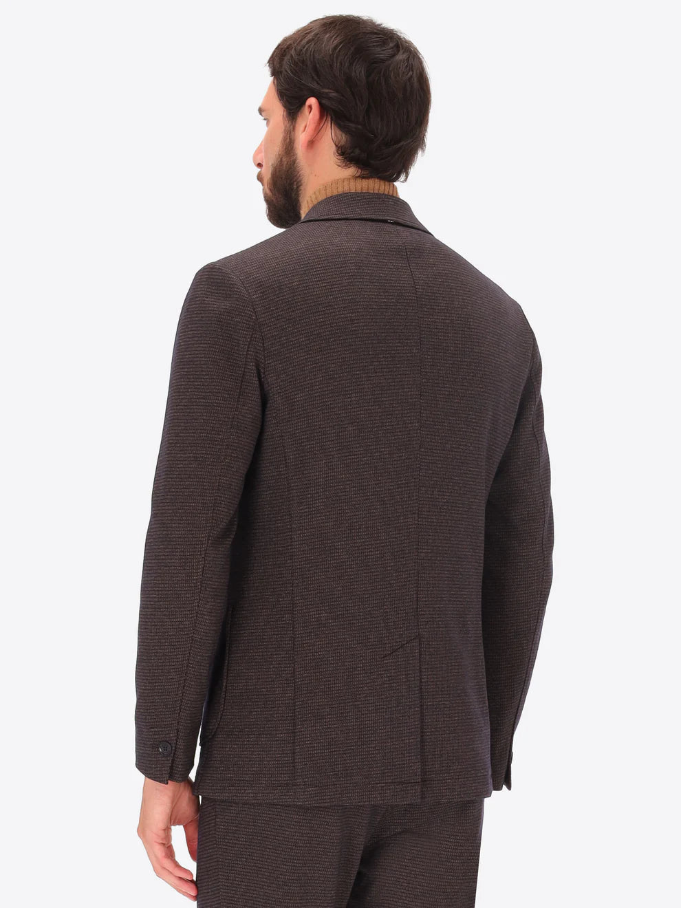 Male model wearing micro patterned jacket by distretto12 in brown with back turned