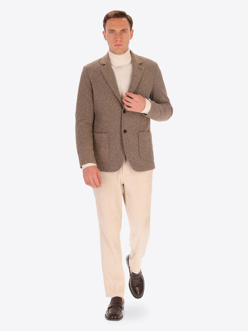 Male model wearing micro pattern jacket by distretto12 in camel colour with corduroy trousers