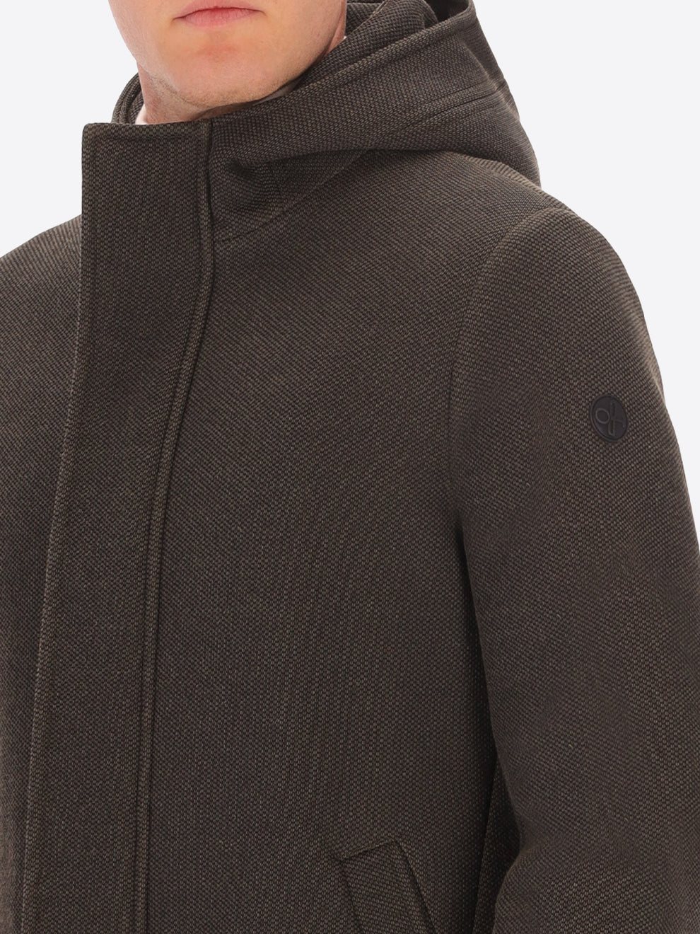 Male model wearing mud coloured parka by distretto12 with close up view