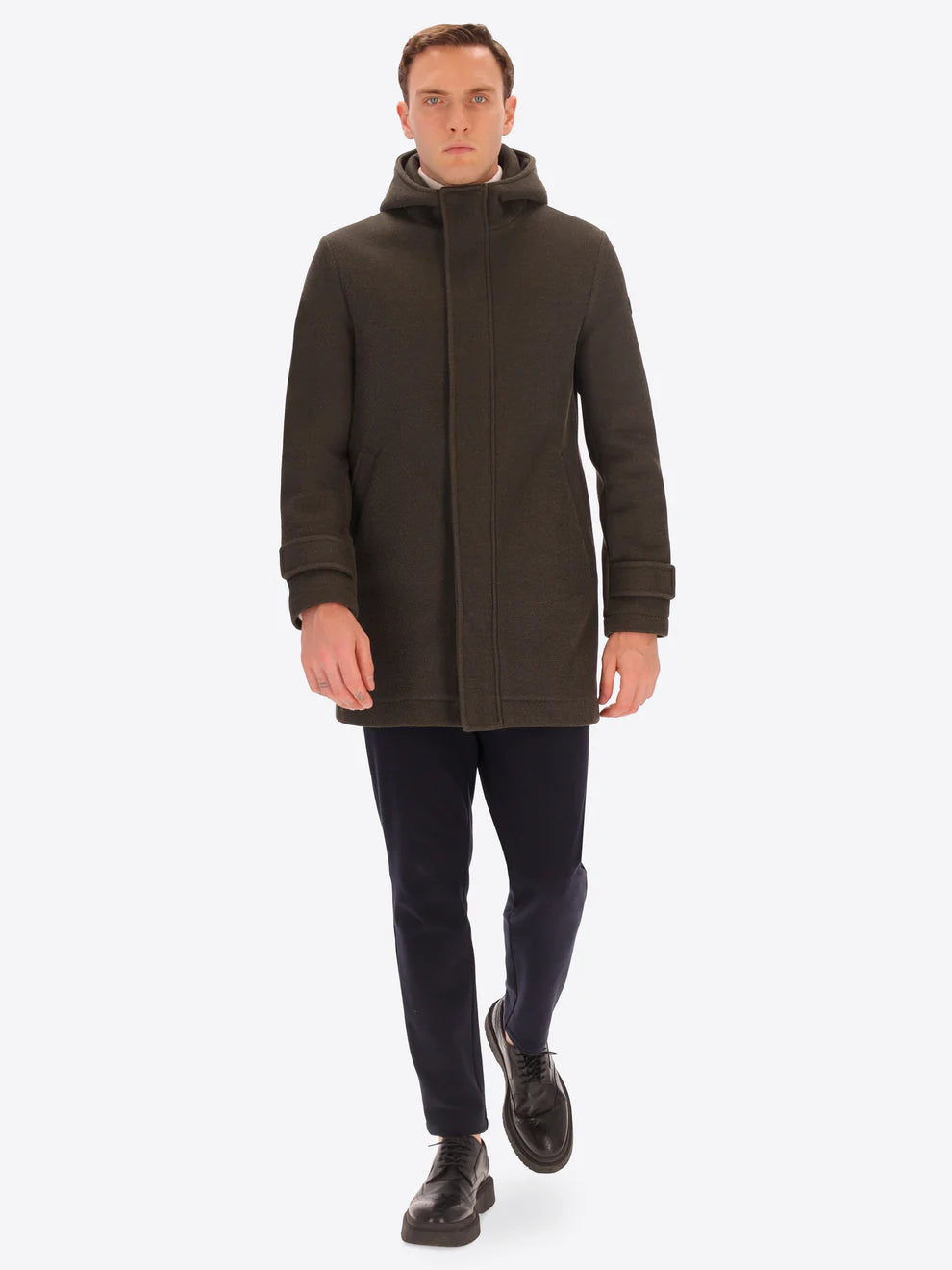 Male model wearing mud coloured parka by distretto12 with straight leg navy trousers