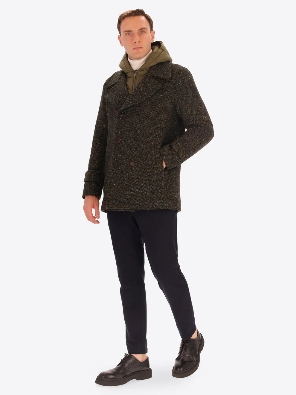 Male model wearing green peacoat with detachable hood insert by distretto12 with micro pattern with navy trousers