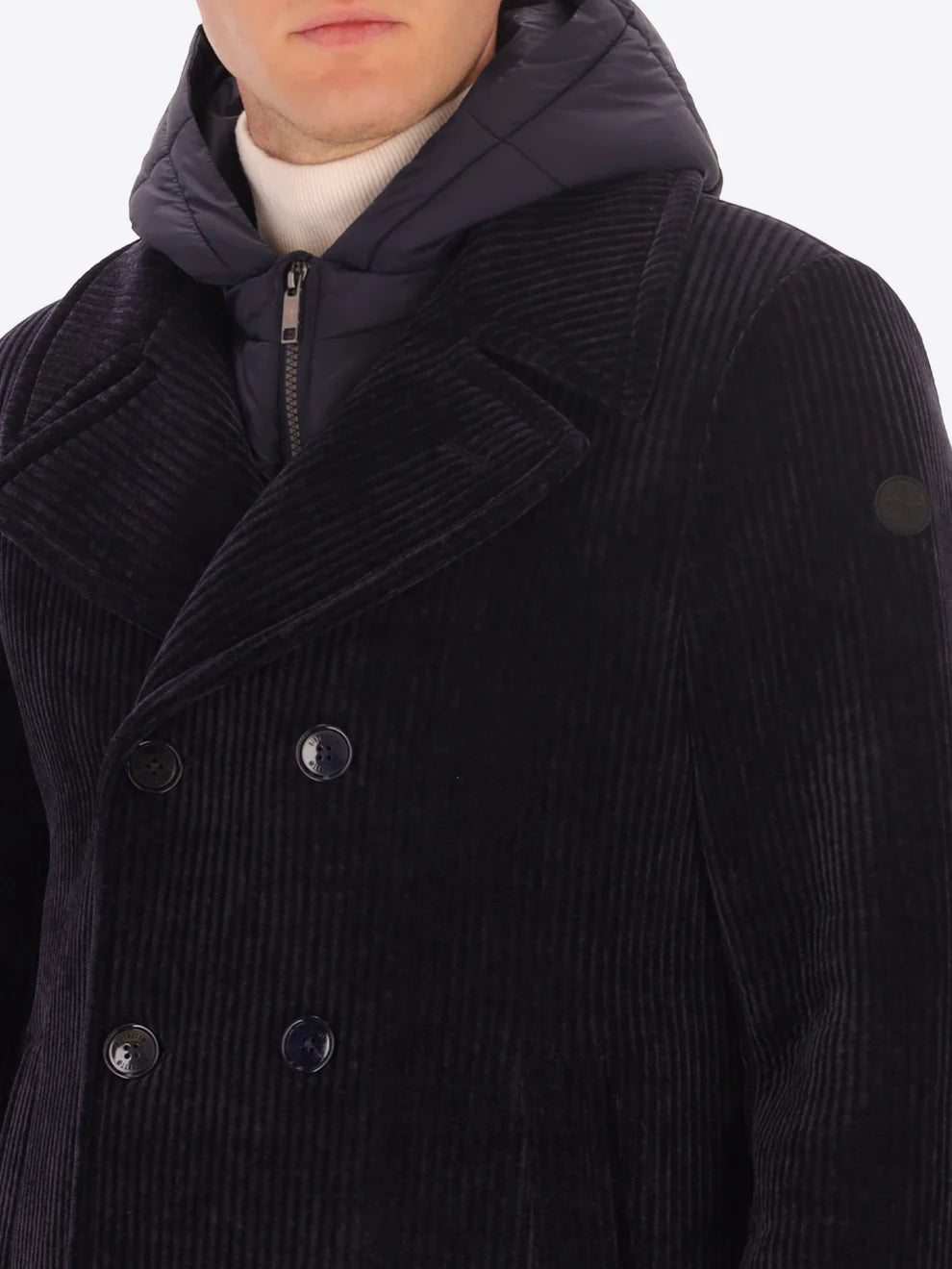 Male model wearing navy corduroy peacoat with detachable hood insert by distretto12 with close up view