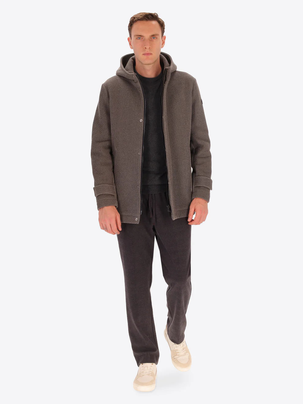 Male model wearing mud coloured parka by distretto12 with coat open and brown trousers