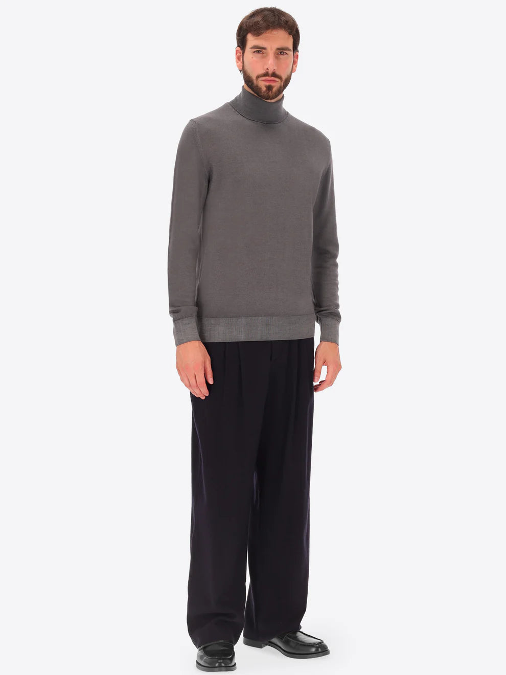 Male model wearing high neck merino blend knitwear by distretto12 in grey with wide leg trousers