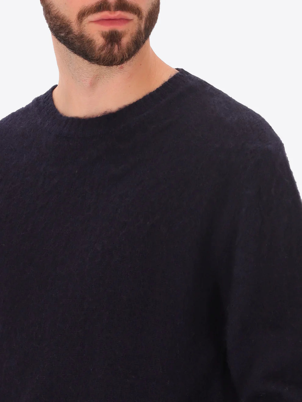 Male model wearing crew neck alpaca blend knitwear by distretto12 in navy with closeup view