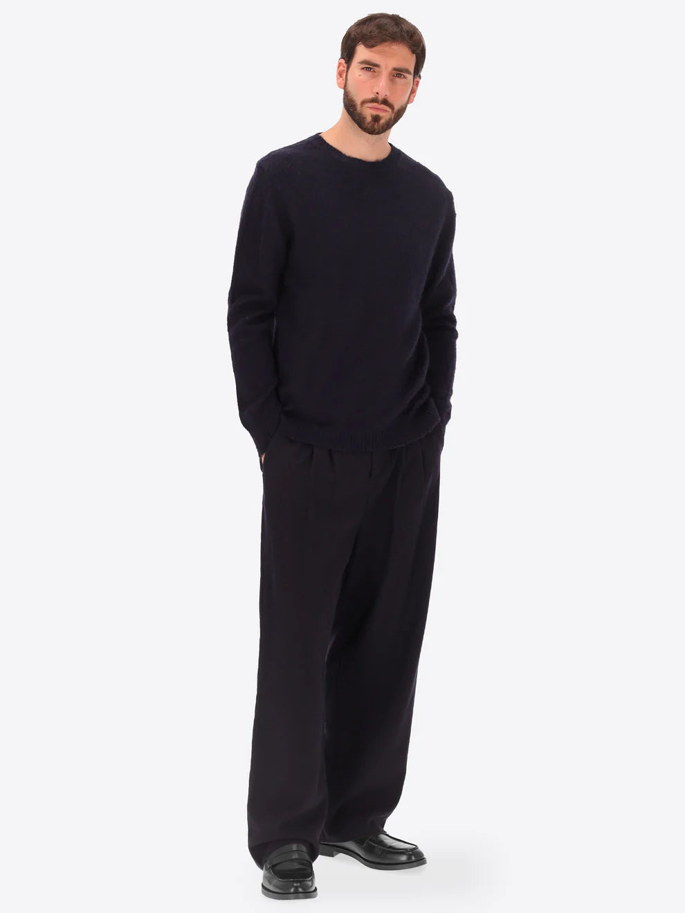 Male model wearing crew neck alpaca blend knitwear by distretto12 in navy with wide leg trousers