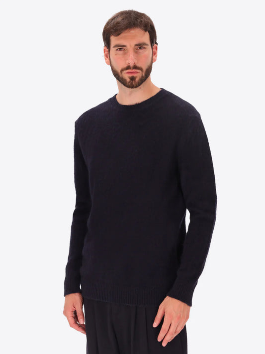Male model wearing crew neck alpaca blend knitwear by distretto12 in navy