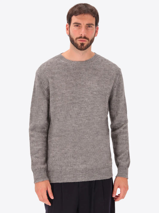 Male model wearing crew neck alpaca blend knitwear by distretto12 in grey