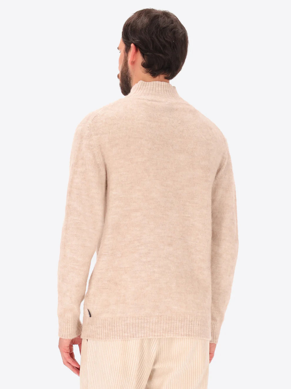 Male model wearing high neck alpaca blend knitwear by distretto12 in cream colour with back turned