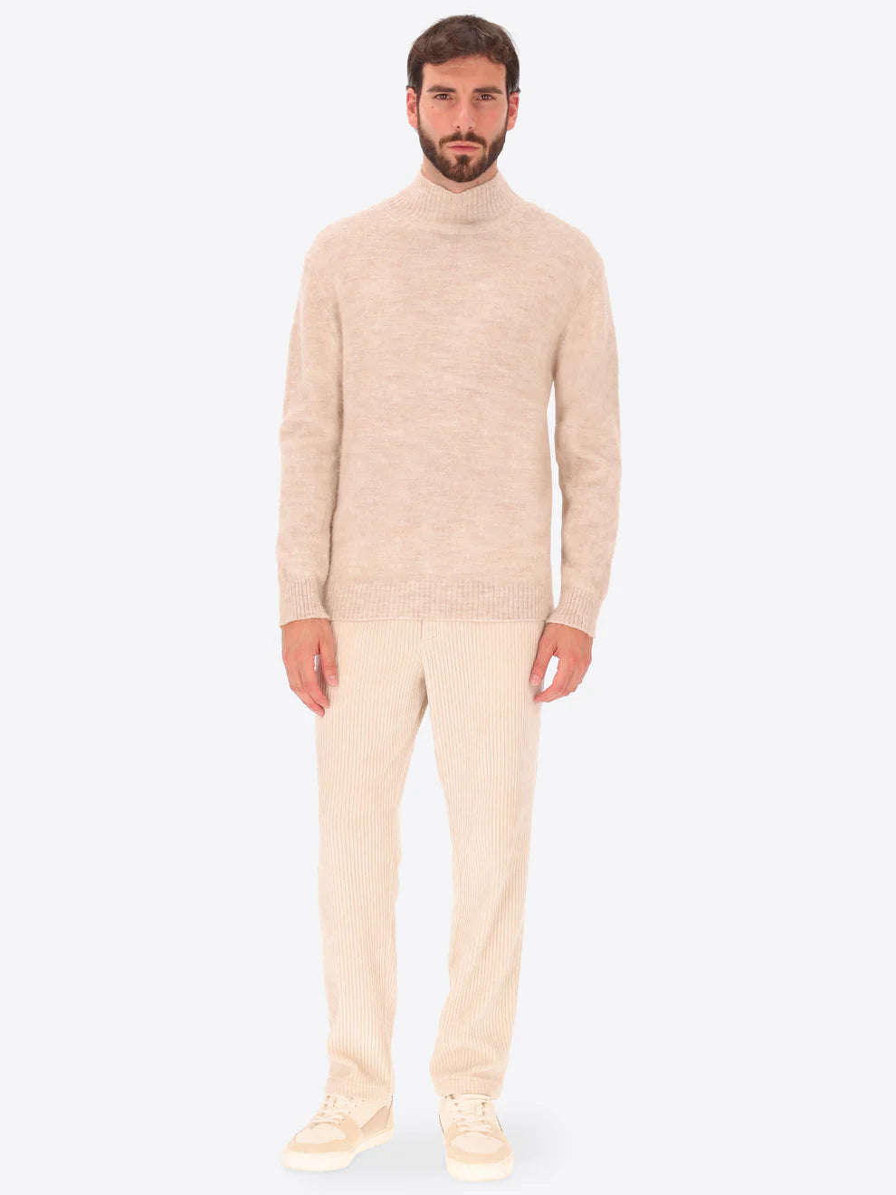 Male model wearing high neck alpaca blend knitwear by distretto12 in cream colour with corduroy trousers
