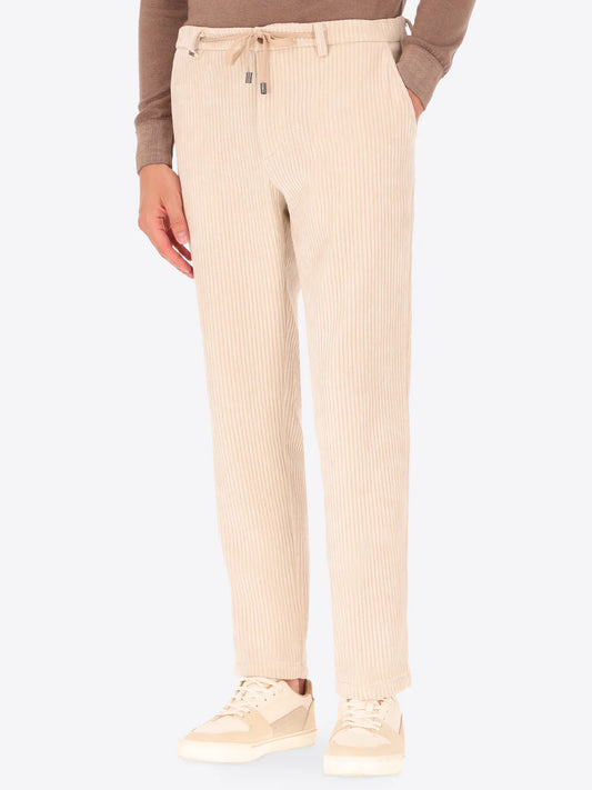 Cream colour corduroy style Distretto12 trousers on a male model