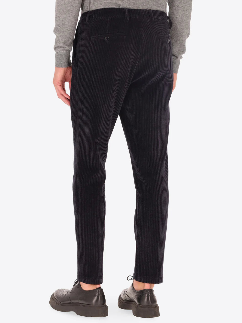 Navy corduroy style Distretto12 trousers on a male model facing away from camera