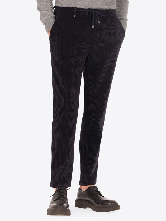 Navy corduroy style Distretto12 trousers on a male model