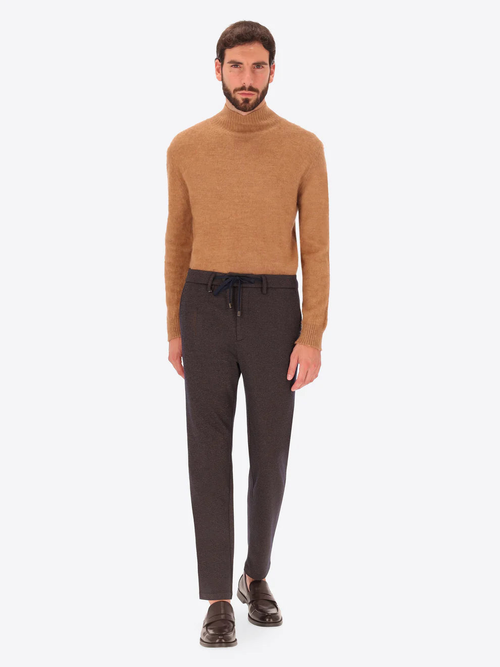 Dark brown Distretto12 trousers with micro check pattern on a male model with camel coloured rollneck knitwear