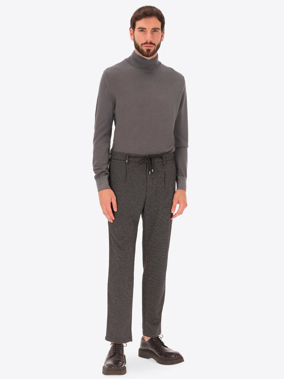 Grey Distretto12 trousers with micro check pattern on a male model paired with grey rollneck knitwear
