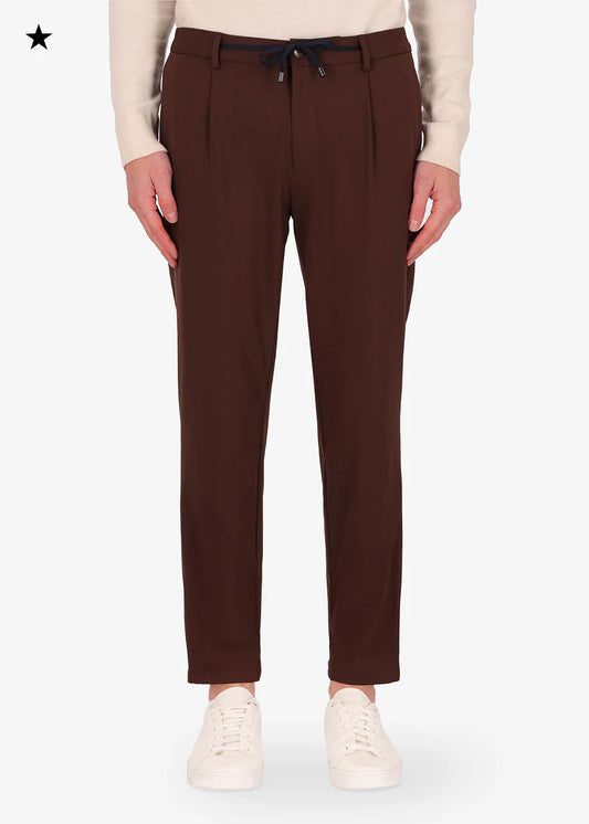An image of a model wearing 32" york trousers High Performance in brown from Distretto 12.