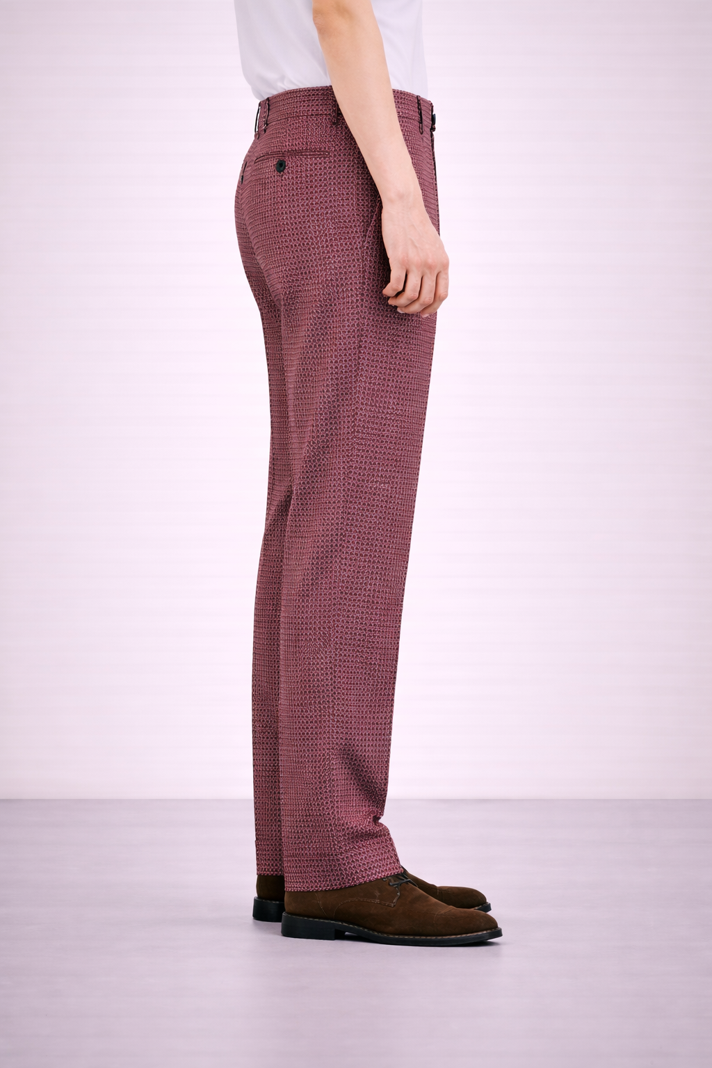 A model wearing Germano 1952 maroon corduroy trousers from the side.