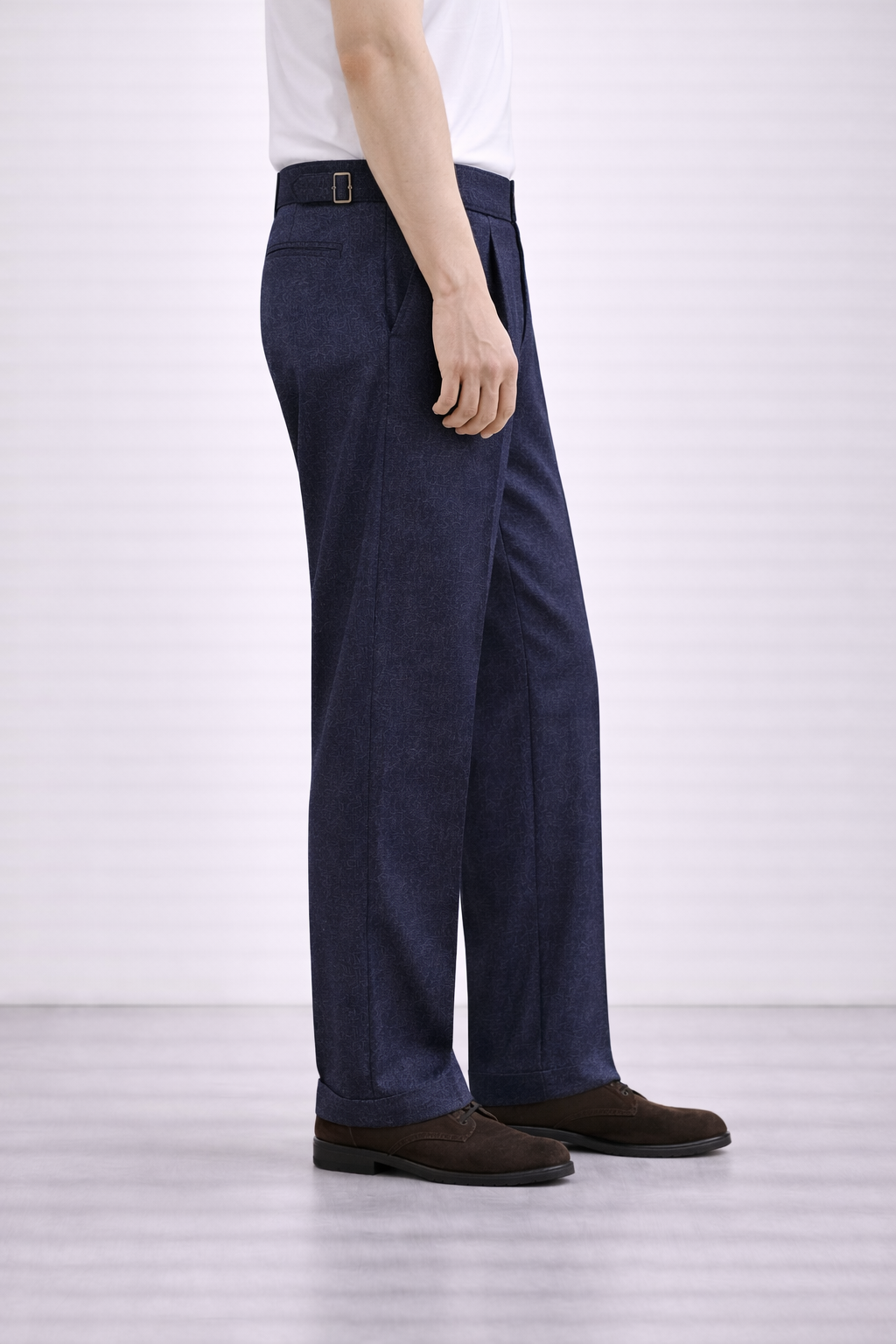 An image of a model wearing Germano 1952 blue trousers with a double pleat taken from the side.