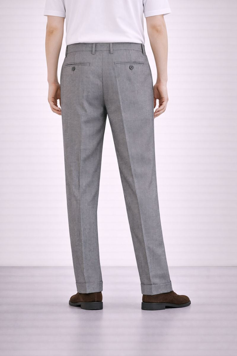 A model wearing Germano 1952 grey trousers with micro pattern from behind.