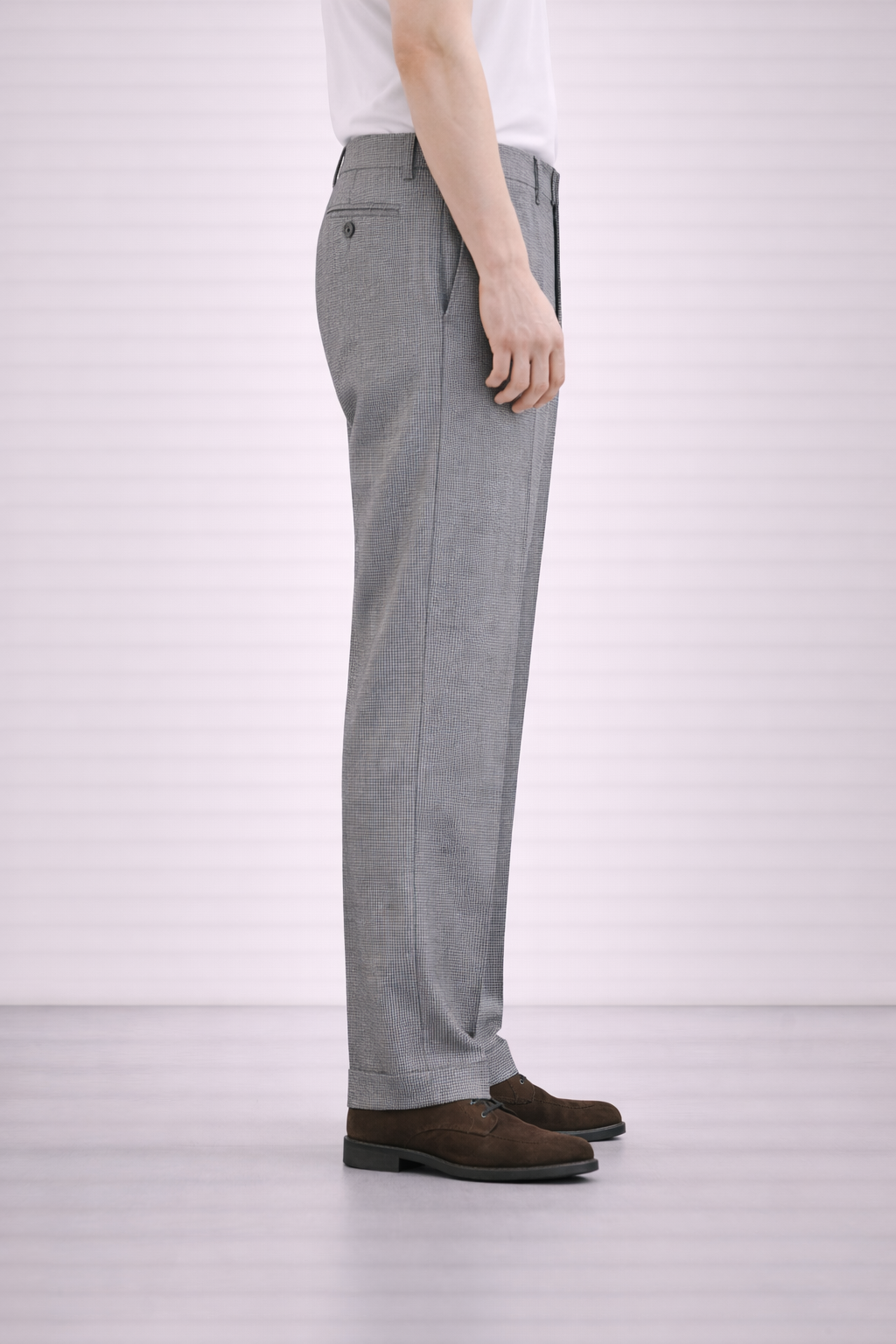 A model wearing Germano 1952 grey trousers with micro pattern from the side.
