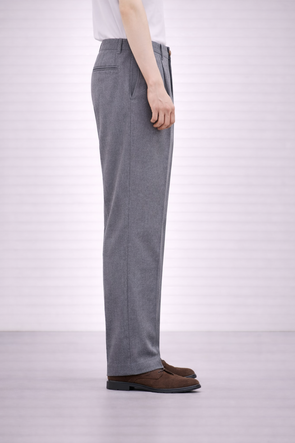 A side on image of a model wearing Germano 1952 grey trousers with a pleat.