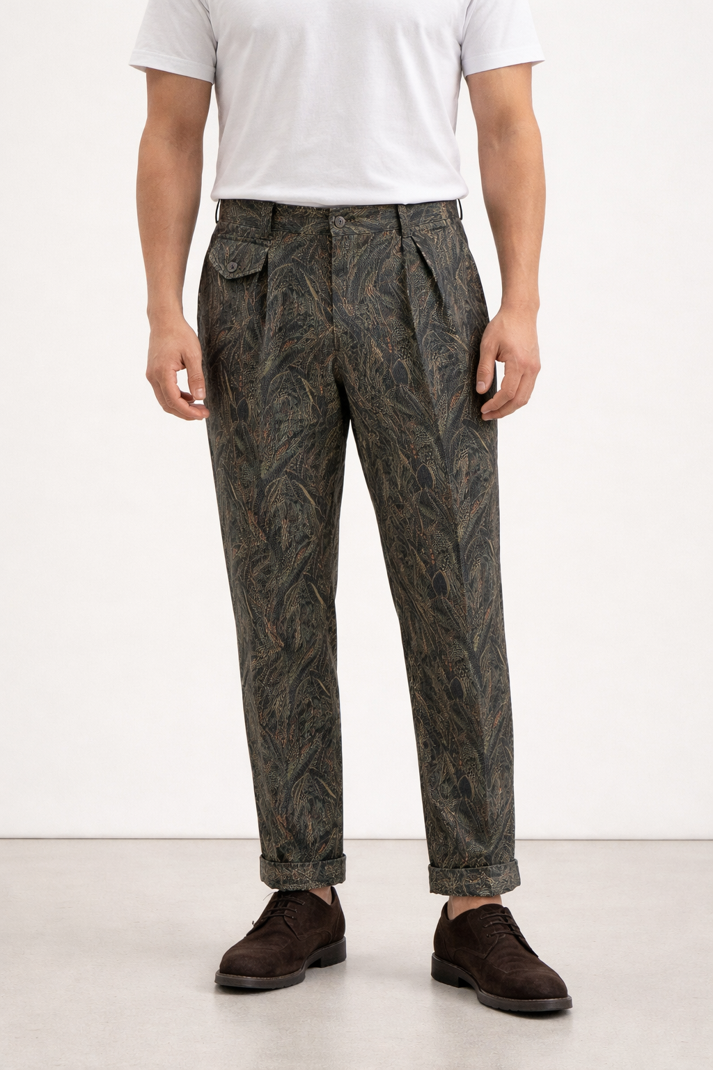 A model wearing Germano 1952 green corduroy trousers with forest themed pattern.