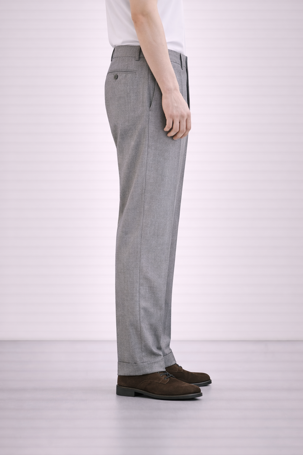A side on image of a model wearing Germano 1952 grey trousers  with a double pleat.