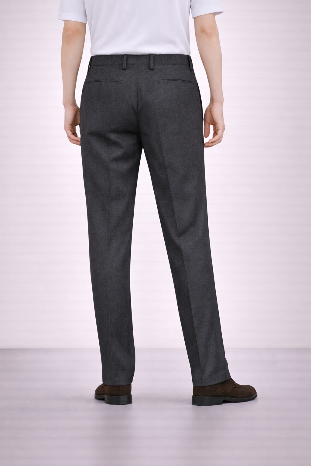 A back angled image of a model wearing Germano 1952 charcoal trousers.