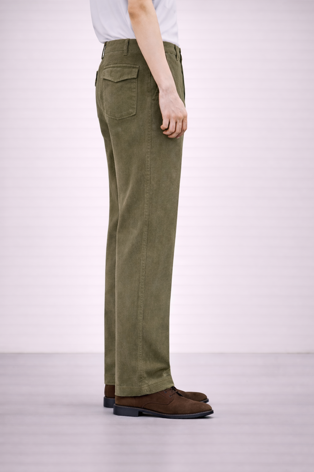 A side on image of a model wearing Germano 1952 olive moleskin trousers with a single pleat.