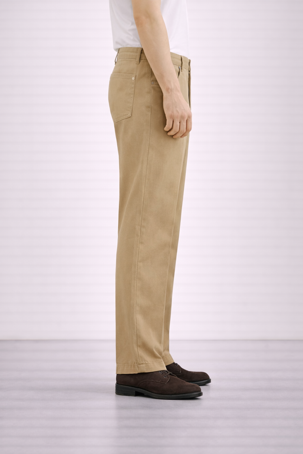 A side on image of a model wearing Germano 1952 tan chinos with a pleat.
