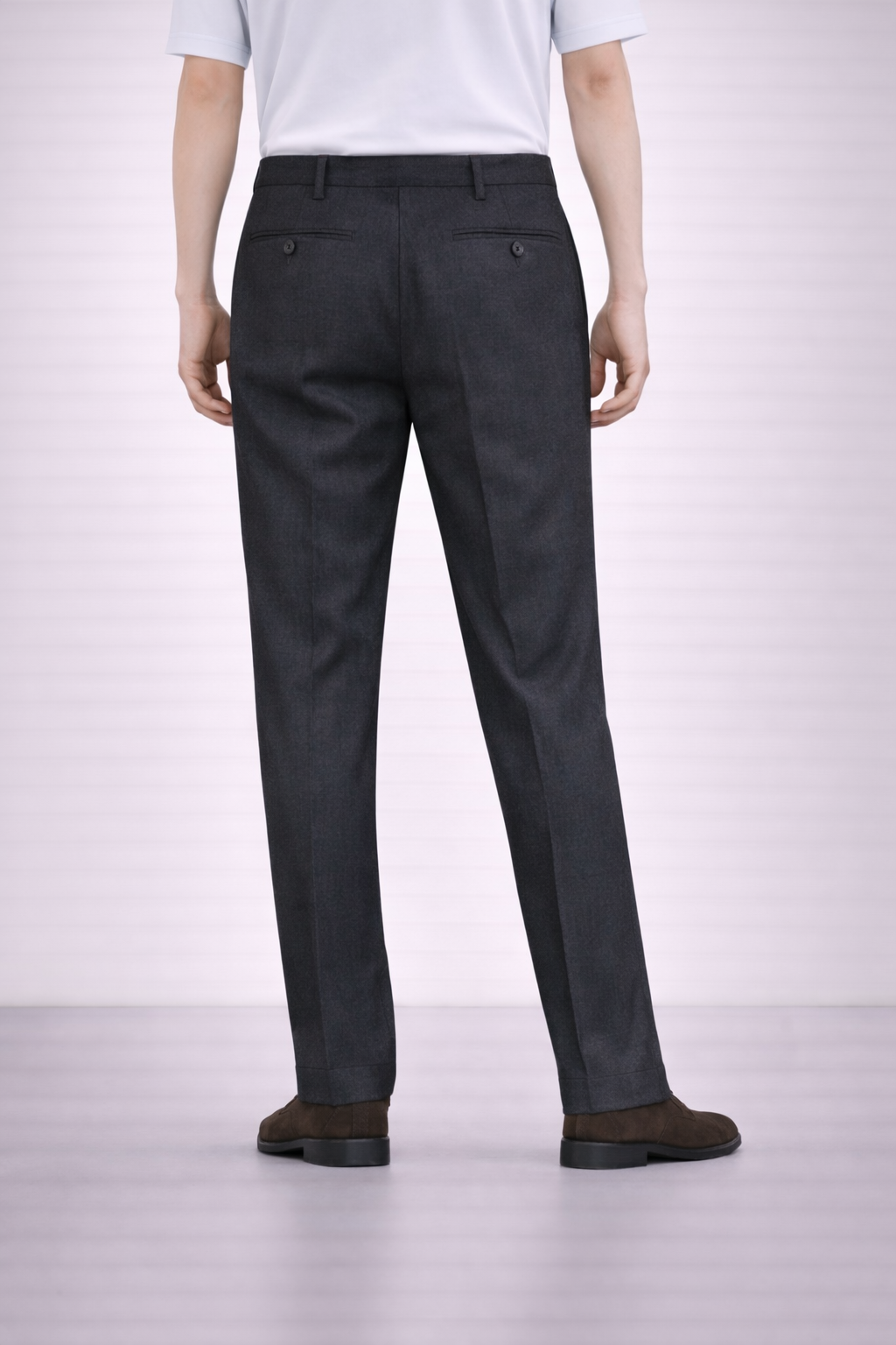 A back angled image of a model wearing Germano 1952 charcoal trousers with slim fit and single pleat.