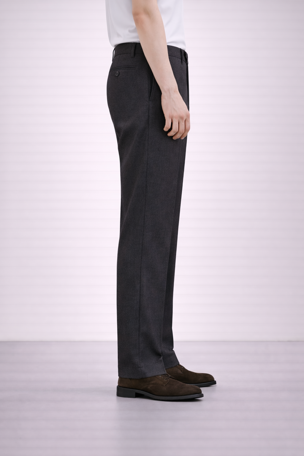 A side on image of a model wearing Germano 1952 charcoal trousers with slim fit and single pleat.