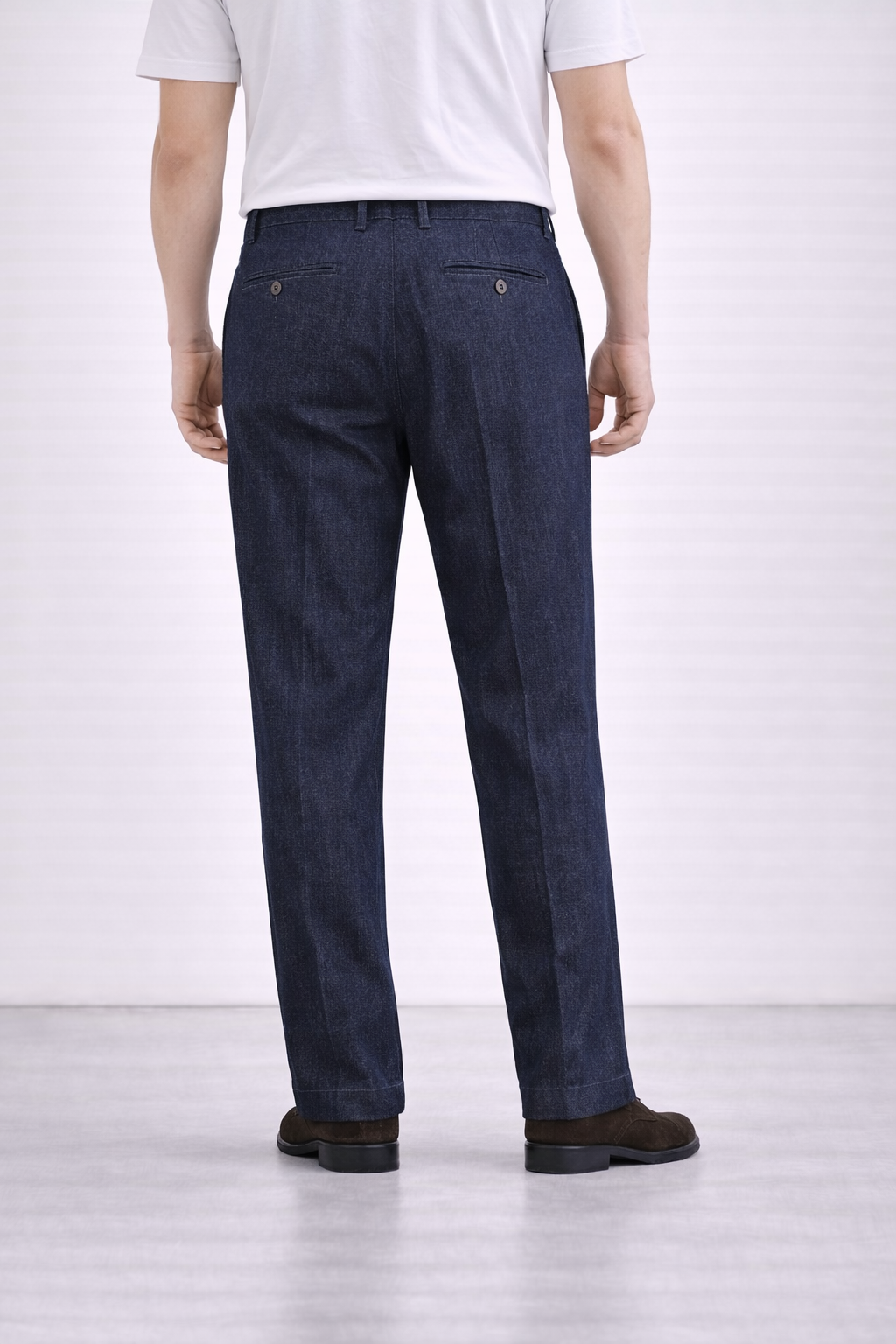 An image of a model wearing Germano 1952 denim trousers with a pleat taken from behind.