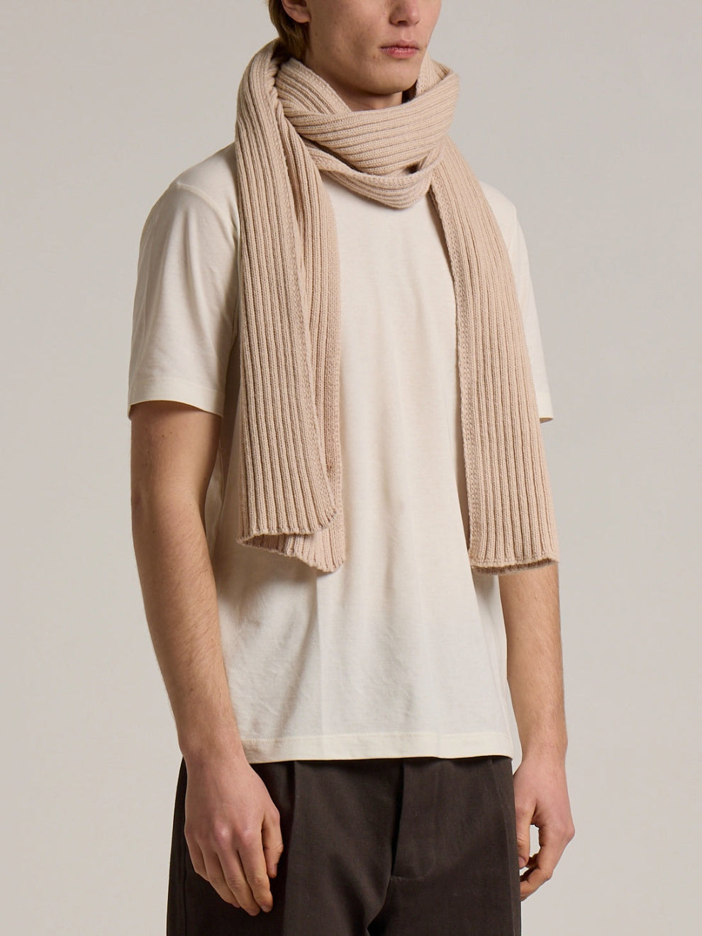 A model wearing a ribbed Wool&Co wool scarf in cream colour
