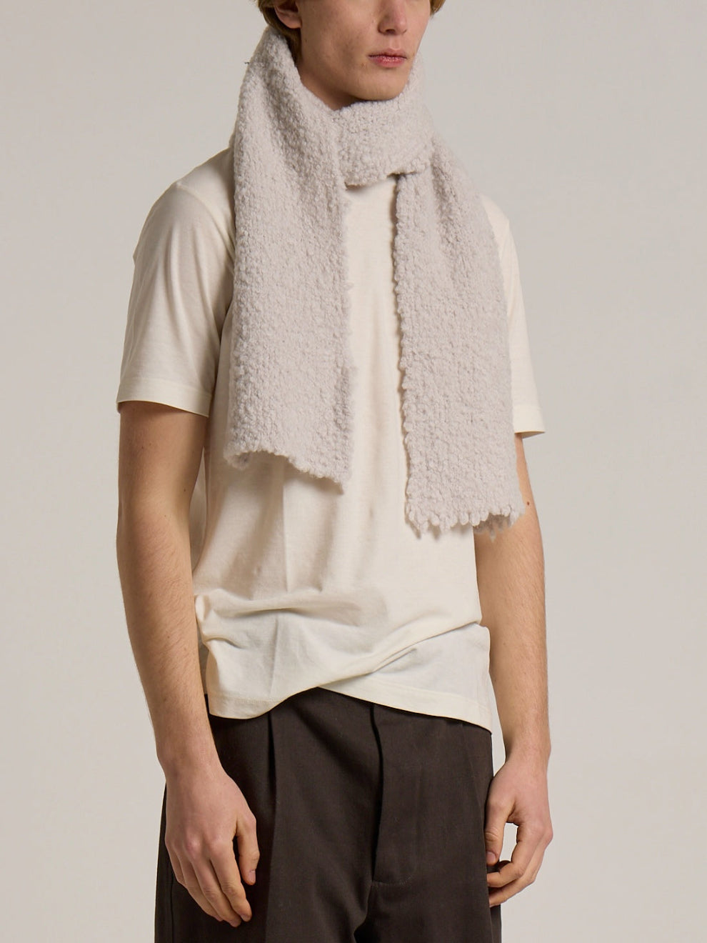 A model wearing a Wool&Co boucle feel scarf in cream colour.
