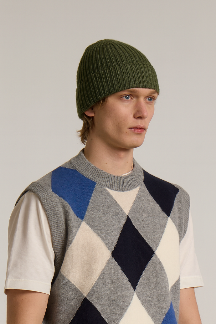 A model wearing a Wool&Co Merino wool blend beanie hat in moss green